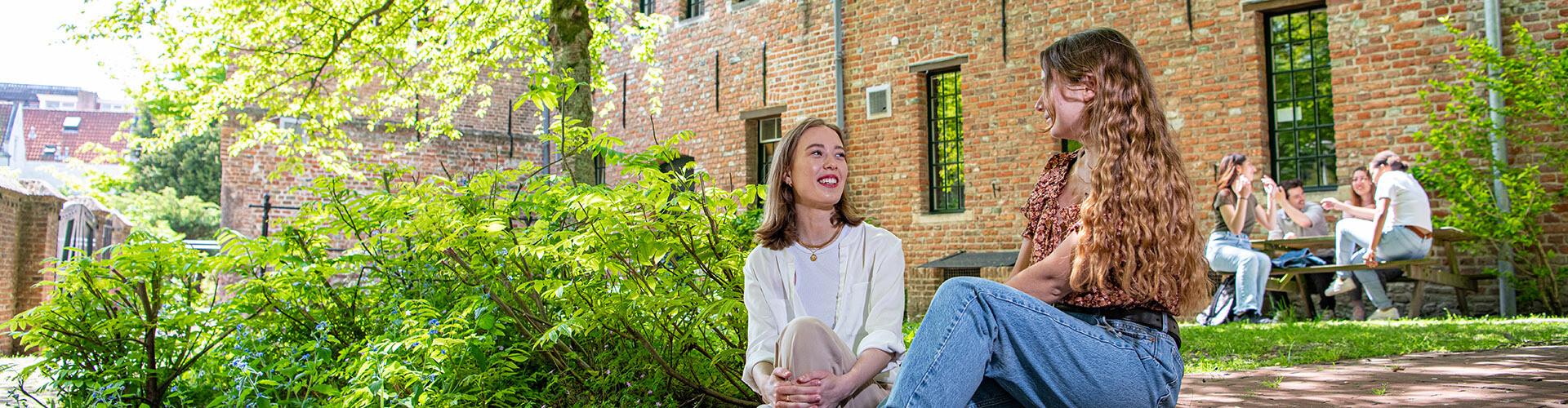 Two female HZ students are talking in the garden of the Middelburgse Abbey