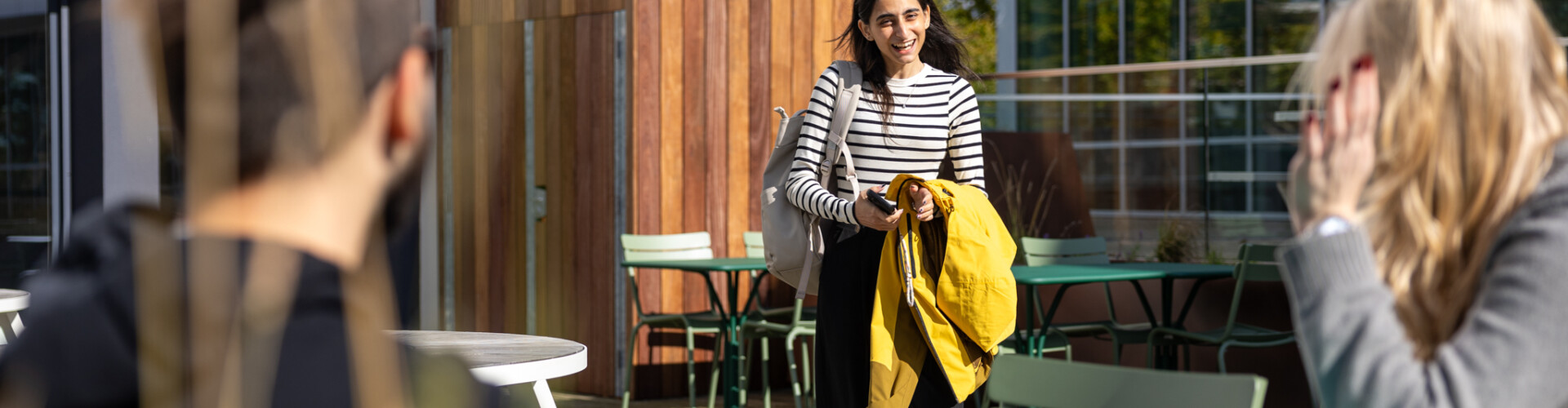 A female student approaching two other students