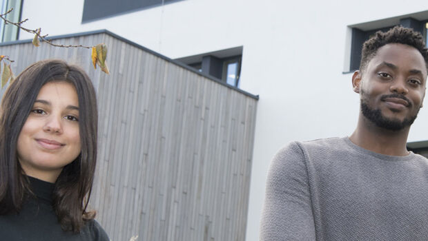 A female and male international student, who study abroad at HZ University of Applied Sciences in the Netherlands, standing before the university building in Middelburg, Zeeland.