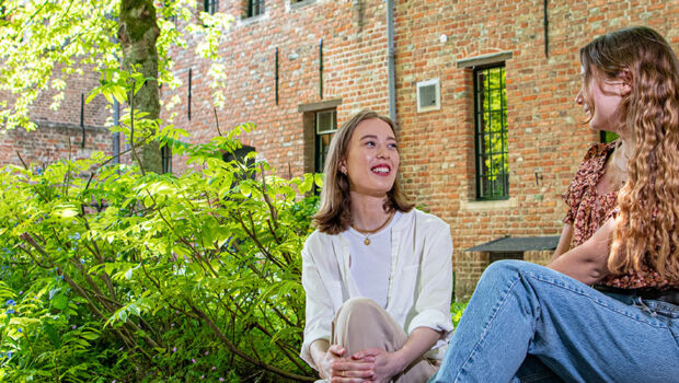 Two female HZ students are talking in the garden of the Middelburgse Abbey