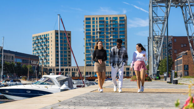 Three international students walking and talking by the harbour in Vlissingen